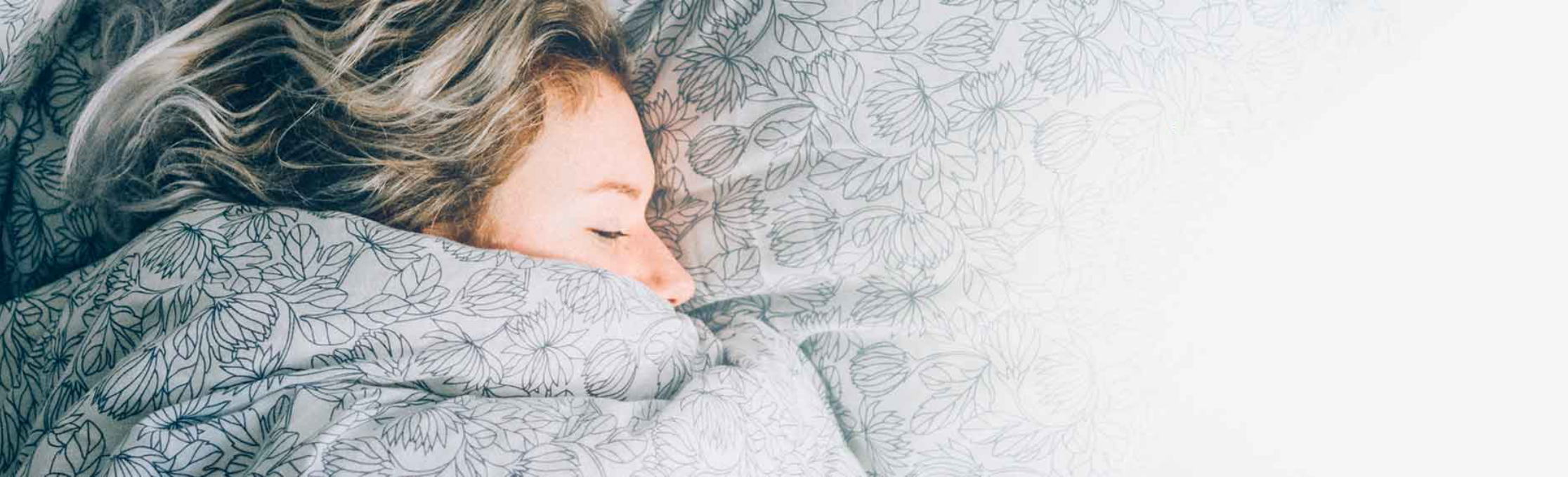Mujer durmiendo envuelta en una manta