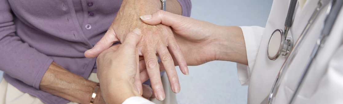 médico revisando la mano del paciente para determinar el tipo de dolor de la artritis